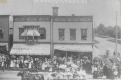 Cadillac-Parade-Early-1900s-parade-On-The-Corner-Of-Cass-And-South-Mitchell-Wilsons-Saloon-and-the-Rice-And-Cassler-Business-are-in-the-background