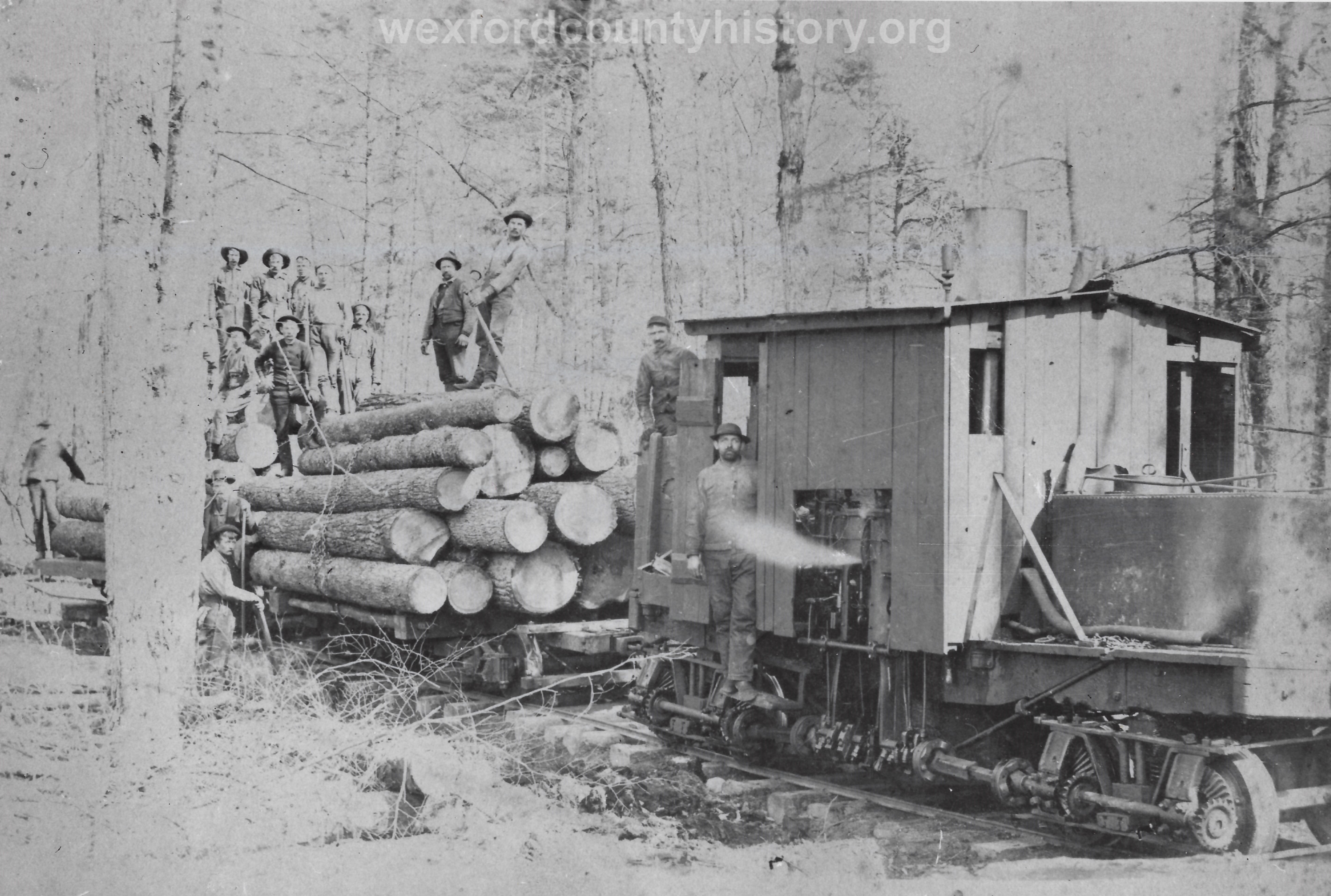 Cadillac-Lumber-Locomotive-And-Car-With-Lumberjacks-On-Stacked-Lumber